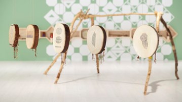 I förgrunden samiska trummor med text och bild inpräntat på trumskinnet, i utställningen Art and Truth-Telling. I bakgrunden stommen till en samisk kåta.